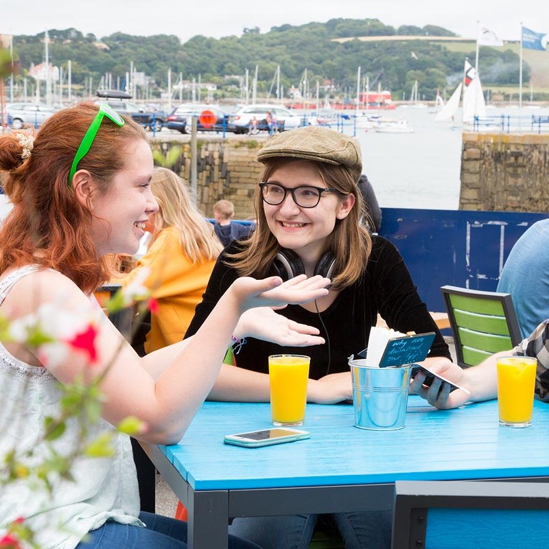 Falmouth University students drinking orange juice at table
