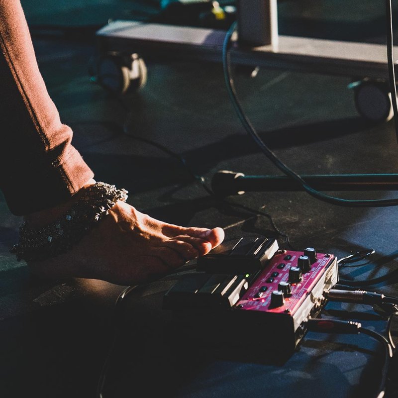 A foot wearing bells resting on a loop pedal