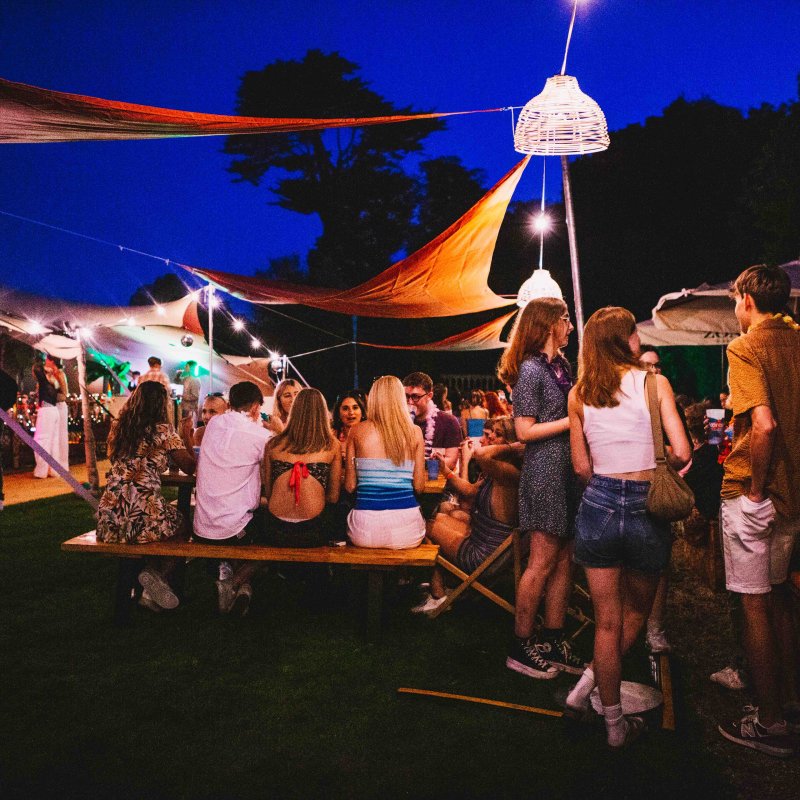 Students sat outside together at an evening event