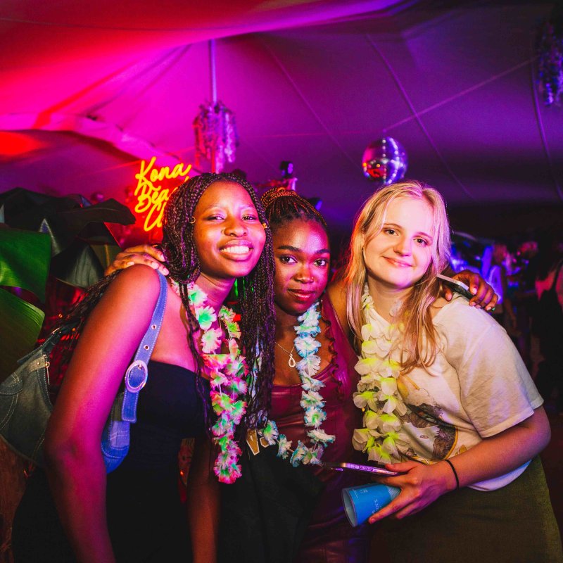 Three students smiling at a freshers event