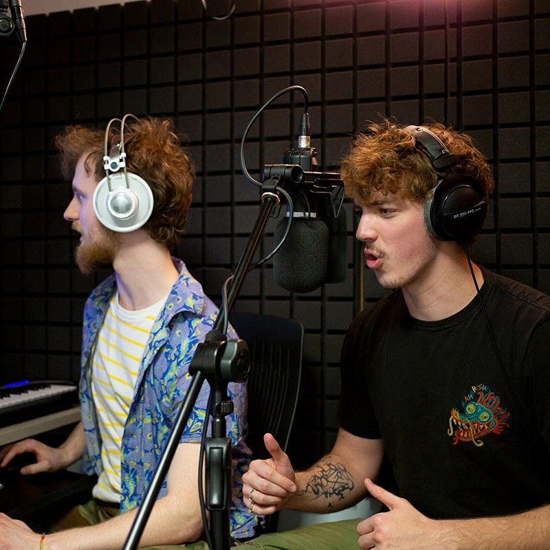 Two students working in an audio booth at the Games Academy