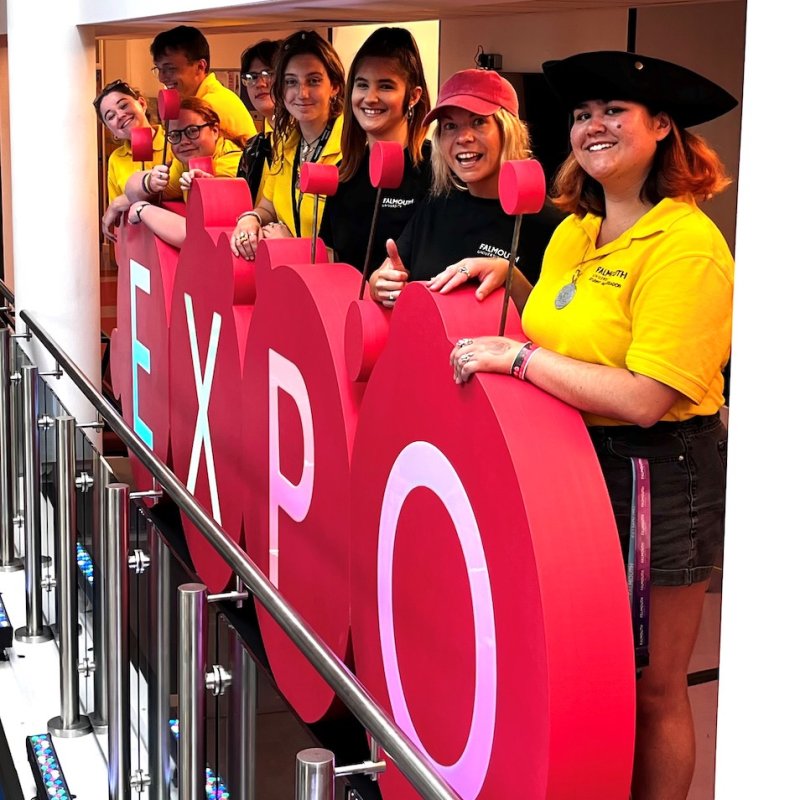 Falmouth University staff and student ambassadors behind Games Expo sign