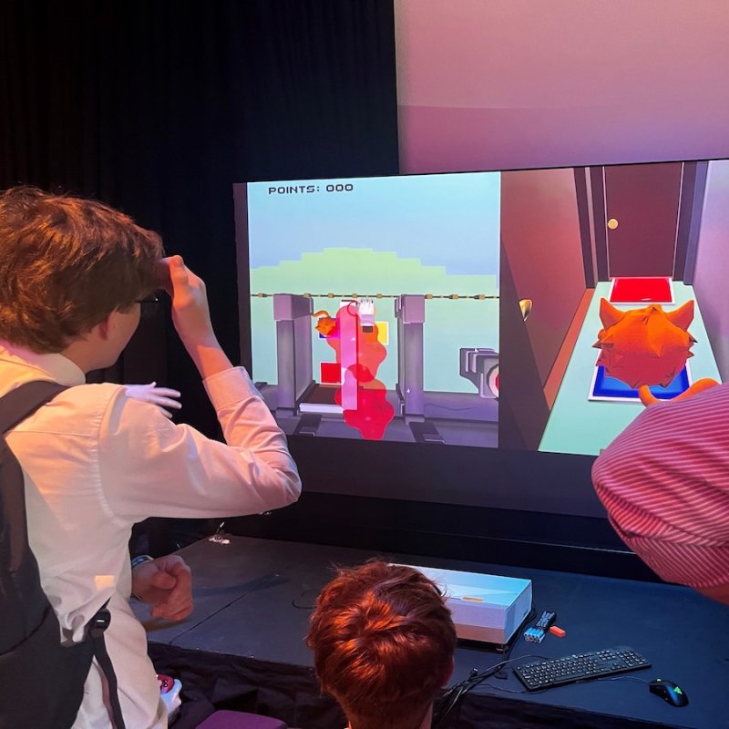 Three people playing a computer game at Falmouth University's Games Expo