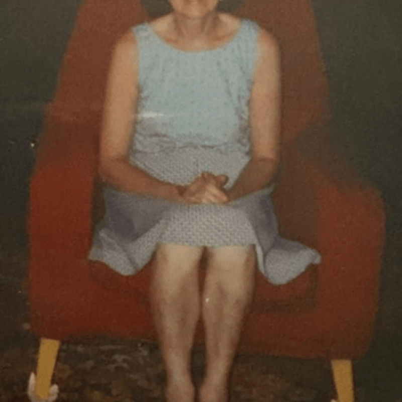 A photograph of a woman sat in a chair