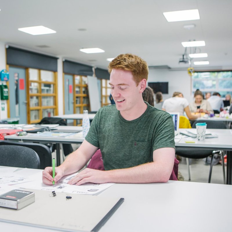 A male student in the Graphic Design studio at Falmouth University