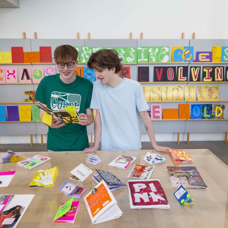 Graphic Design students at a stand of designs