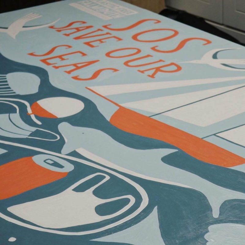 Close up of the SOS Save our Seas mural with a boat and dolphin