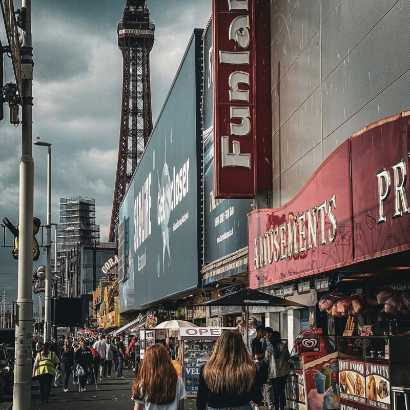 A busy street in Blackpool with the famous tower in the distance 