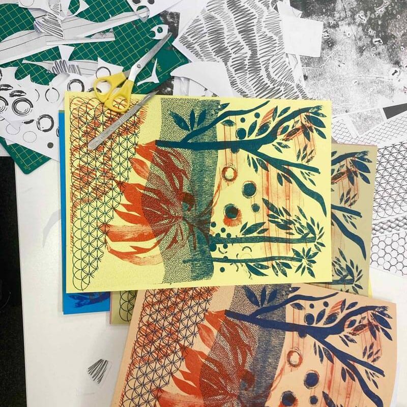 aerial view of a table with Risograph prints on and yellow scissors