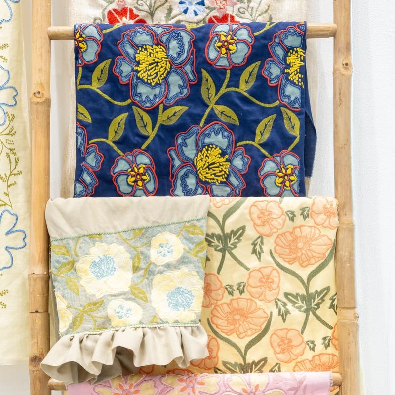 fabric designs hanging from a wooden ladder