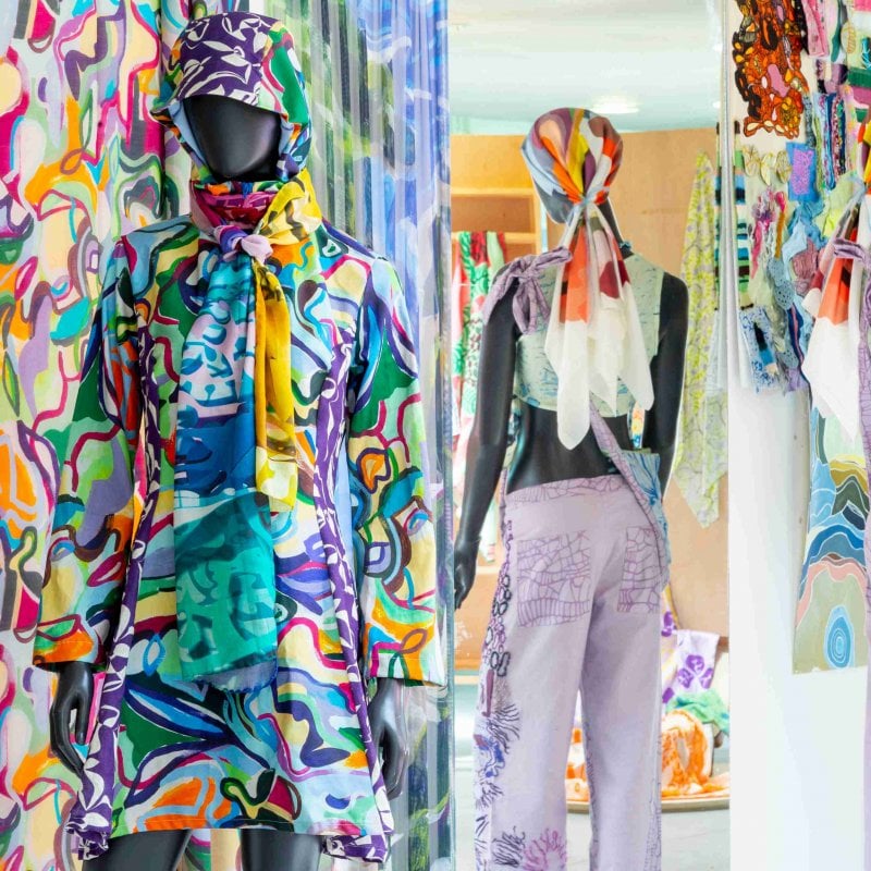 Three mannequins wearing colourful clothing are placed next to each other