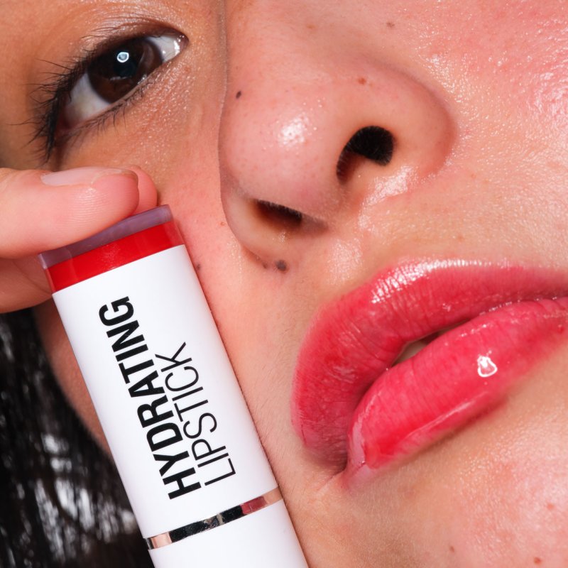 A Falmouth University student holding up a lipstick