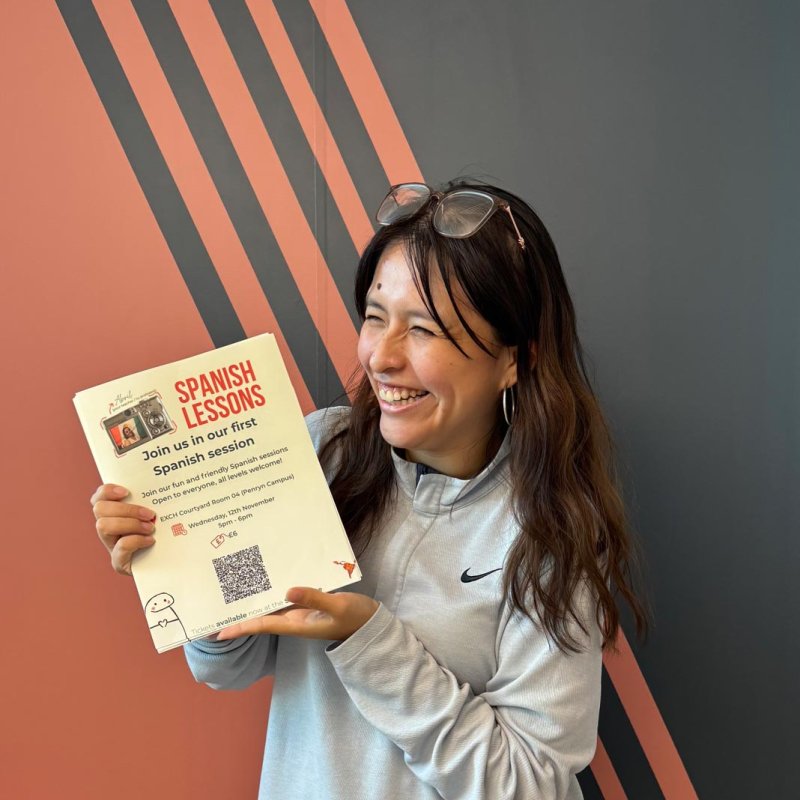 A Theatre & Performance student holding posters for Spanish lessons