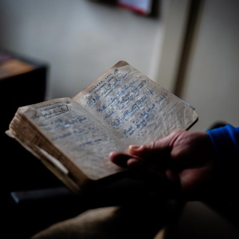 A hand holding an open diary