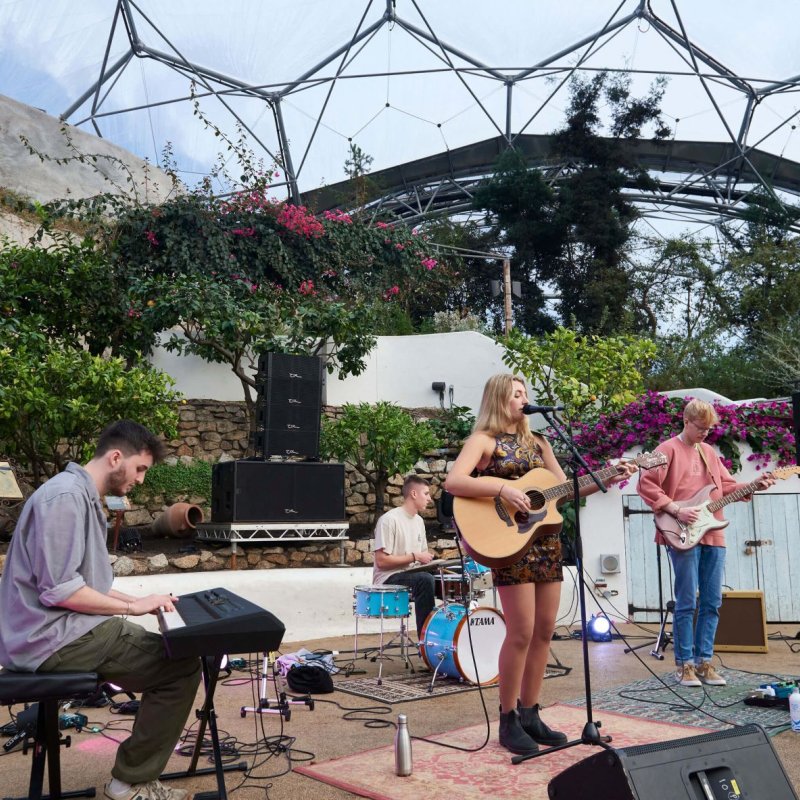 A four-piece band performing at the Eden Project