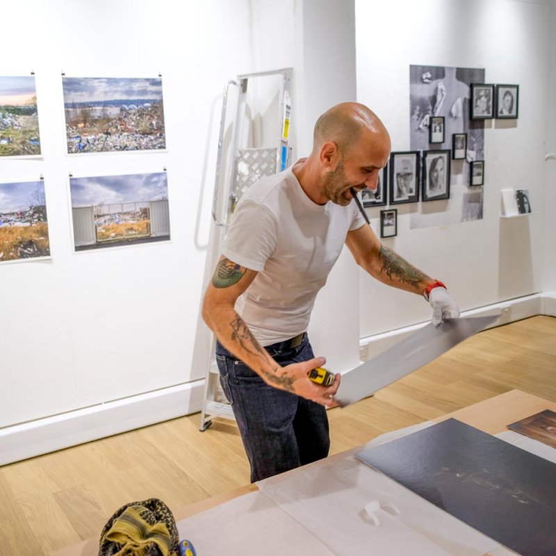 A male Photography MA (Online) student working in a gallery space