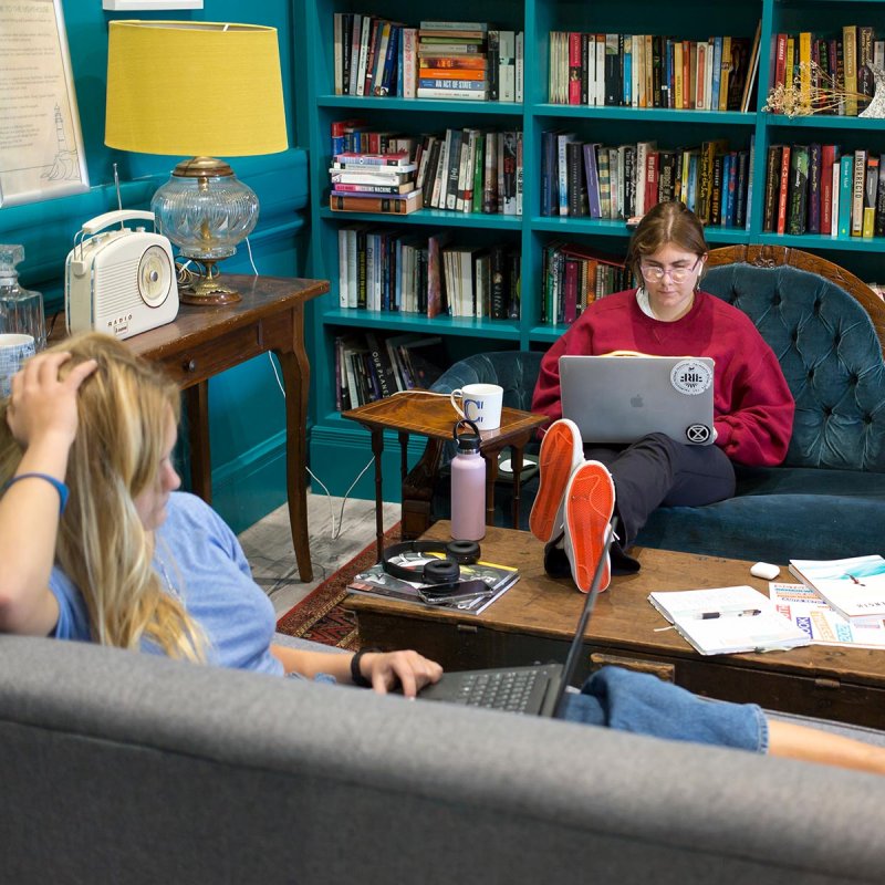 Two female students sitting on sofas in Falmouth University's writing room, the Lighthouse