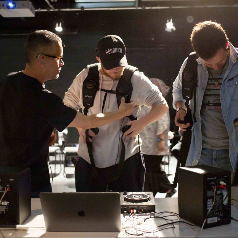 Three people trying on haptic systems