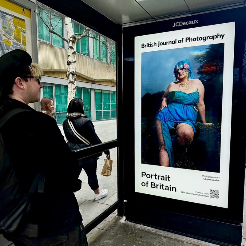 Logan Davies standing with Portrait of Britain winning work