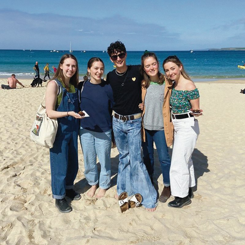 Luca Vaccari and friends stand on Gyllyngvase beach in Falmouth.