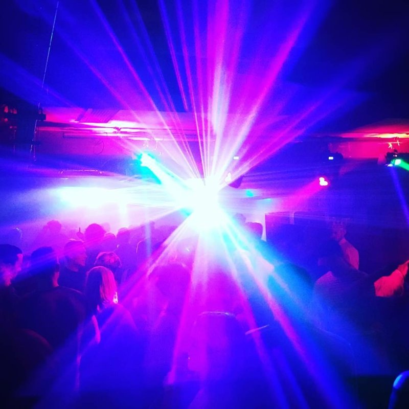 A beam of blue and purple light on a dance floor