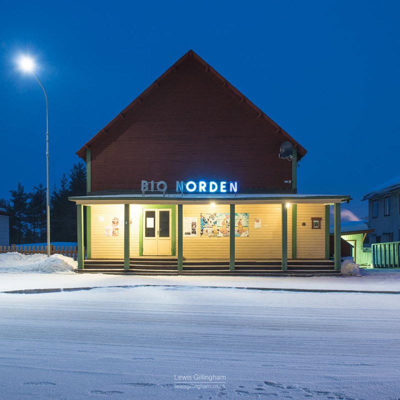 Photograph of a building illuminated at night in the snow, with a sign saying Bio Norden