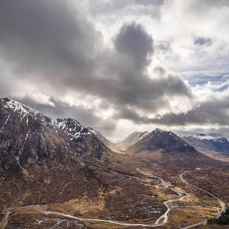View of snow-capped mountains with a winding road in the foreground