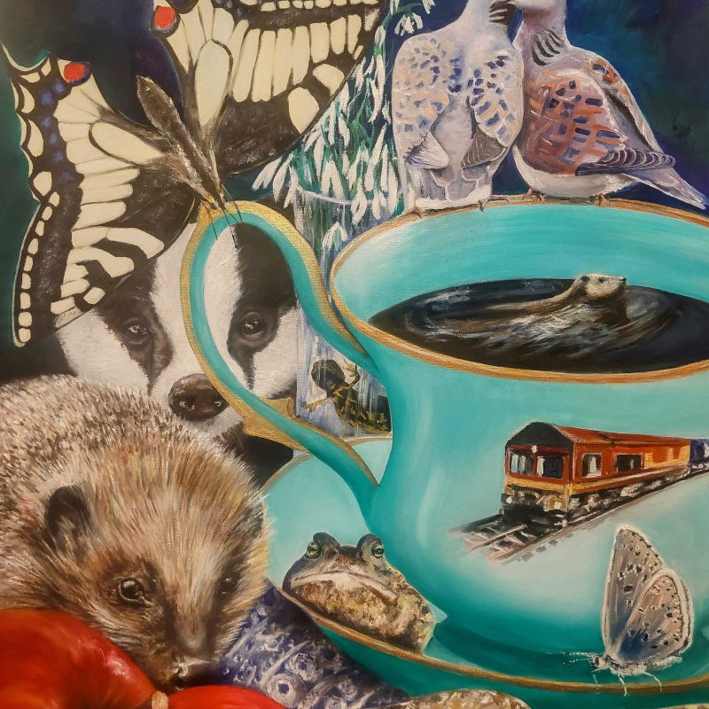 a blue teacup with a butterfly, badger, hedgehog and birds