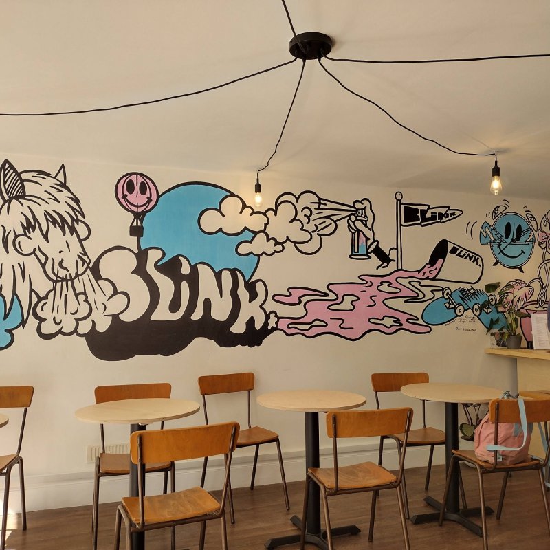 A mural showing a horse, a broken skateboard and a coffee cup