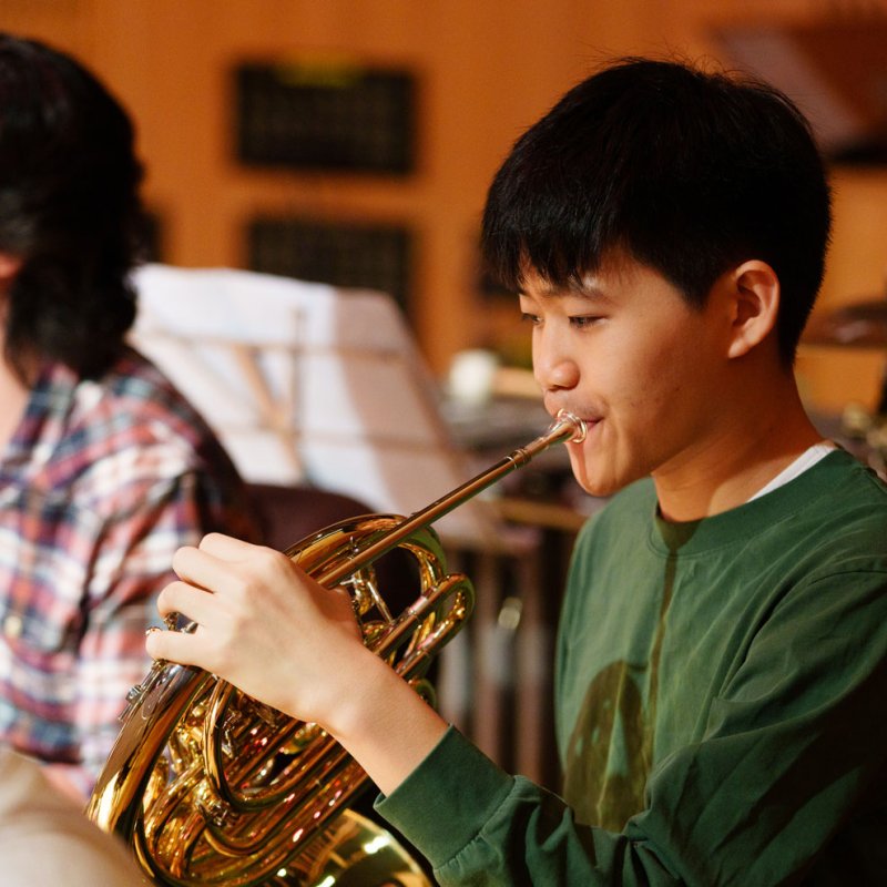 A Music student playing a brass instrument
