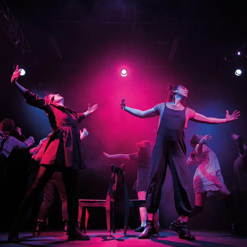 Actors on stage with arms spread