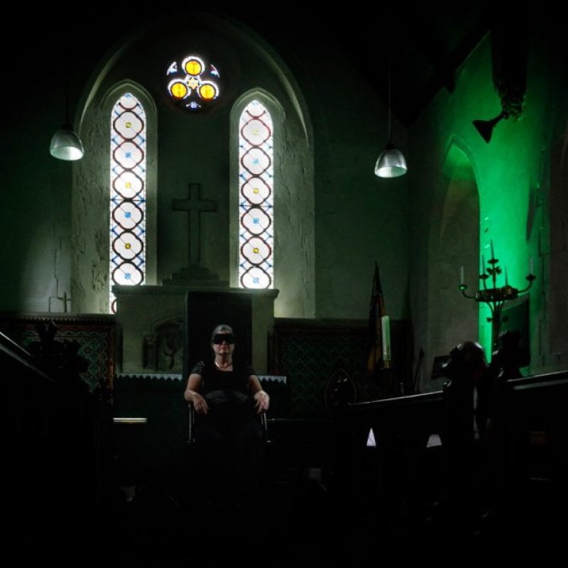 A person sat in a darkened church 