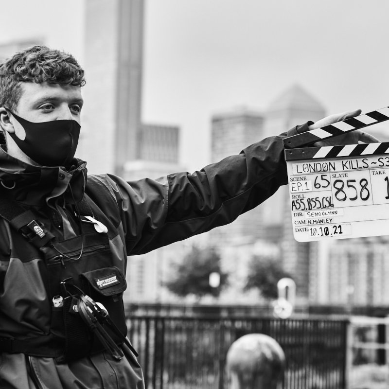 A student uses a clapperboard on the set of London KIlls