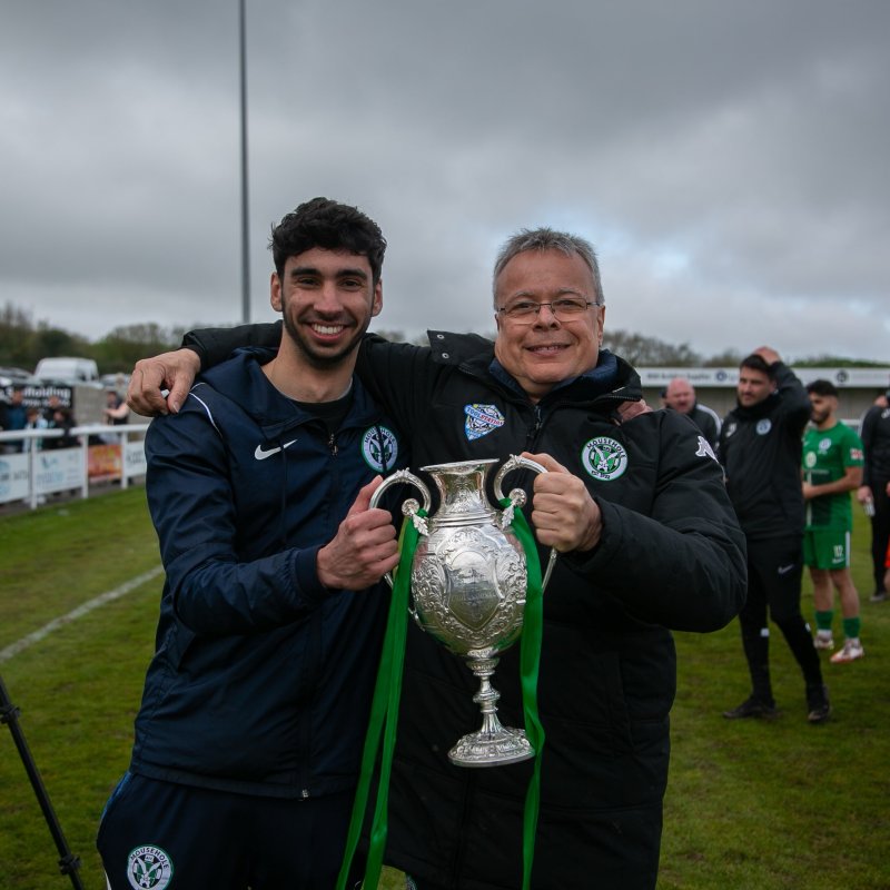 Falmouth University Journalism student posing with trophy at Mousehole AFC match