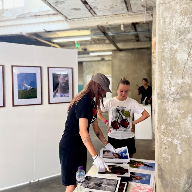 Two people looking at photography work in a gallery space