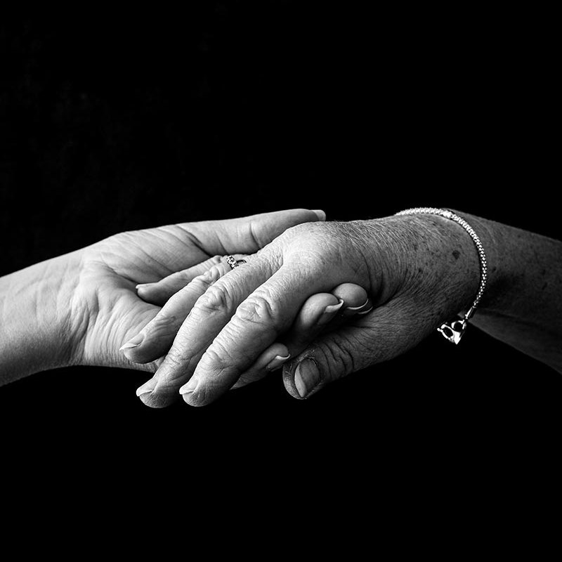 Black and white photograph of two hands holding