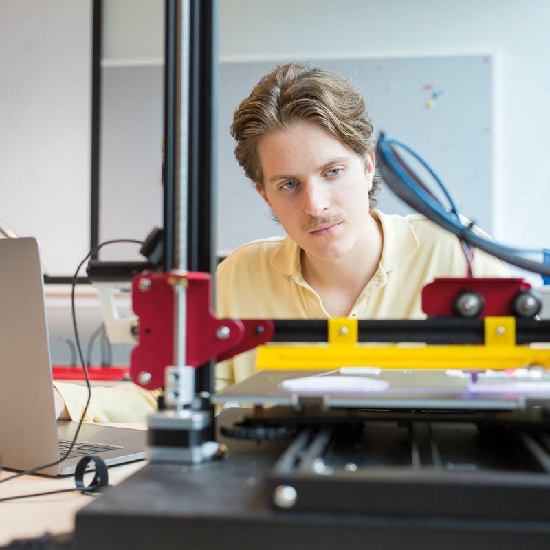 Student at desk working with robotic equipment