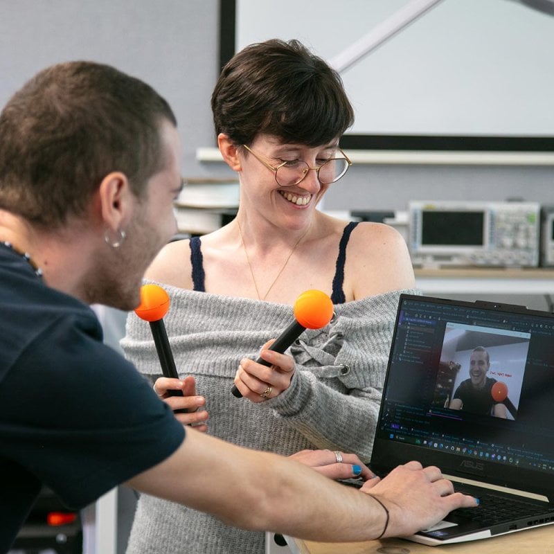 A male and female Robotics student working at a laptop