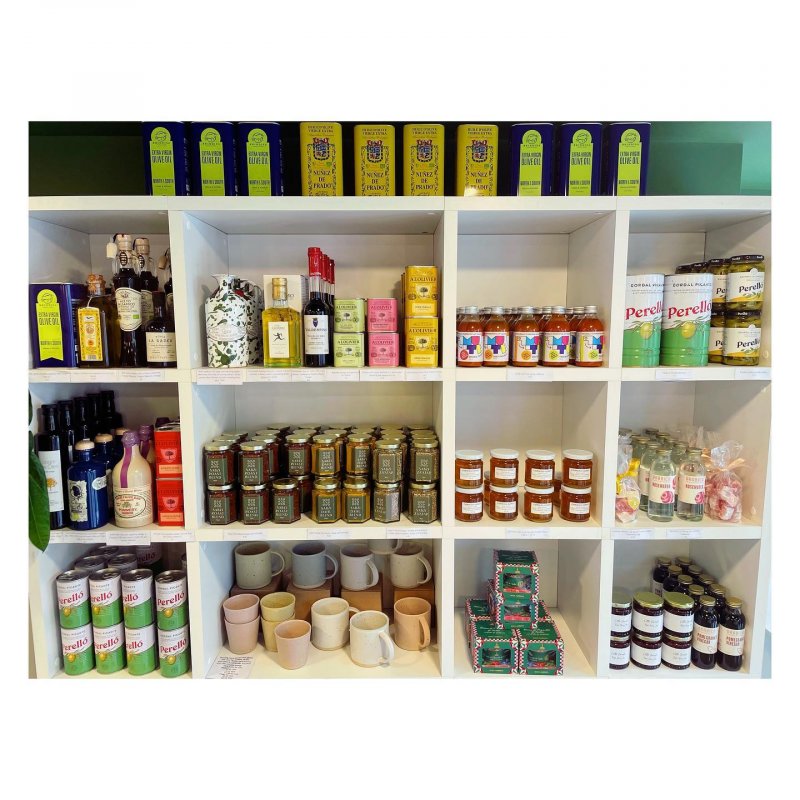 White shelves with a display of jars, tins, and bottles