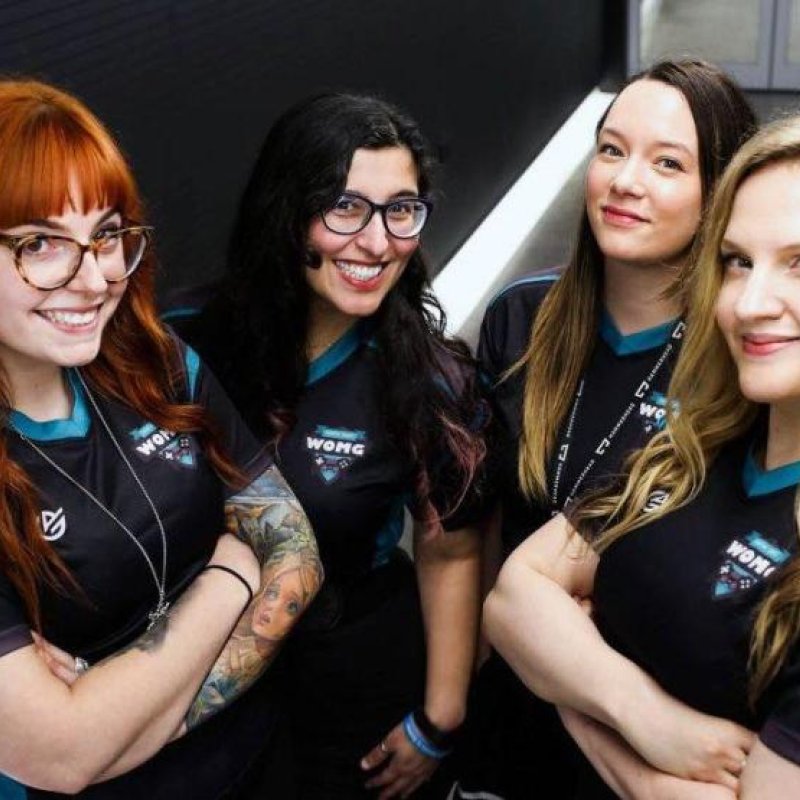 Four women stood together smiling and with their arms folded 