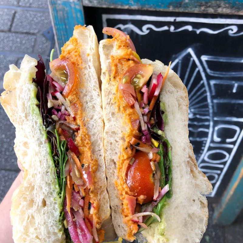 White bread filled with hummus, salad and tomato