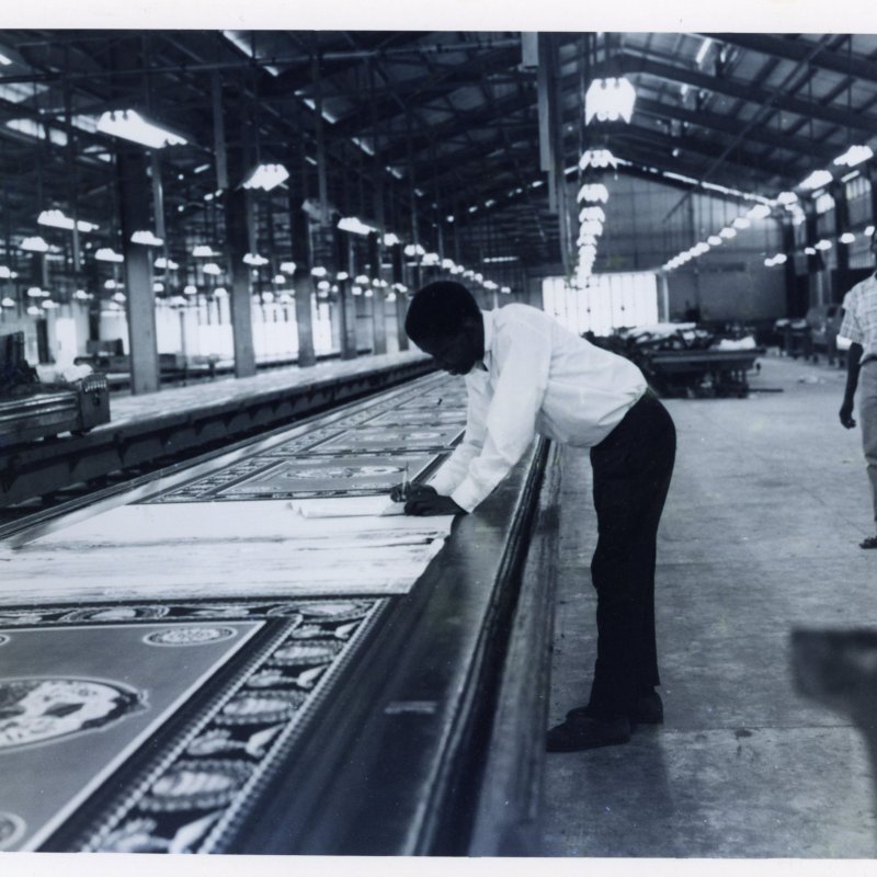 A man crouches over a factory line