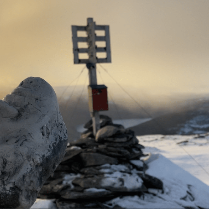 A sculpture of a head on a mountain