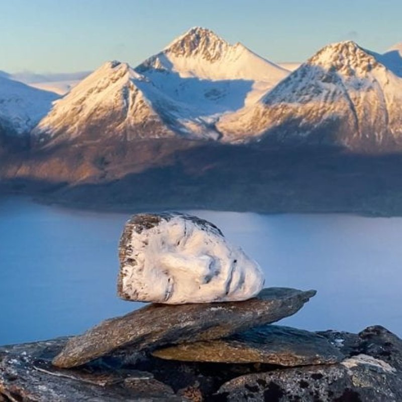 A sculpture of a head on a mountain