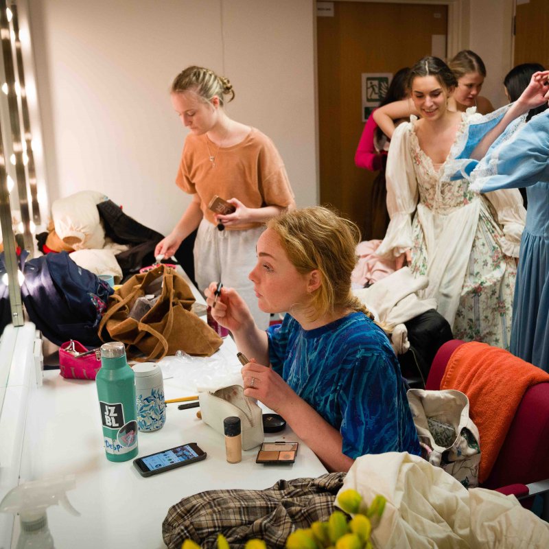 A group of acting students checking makeup and costumes in mirror
