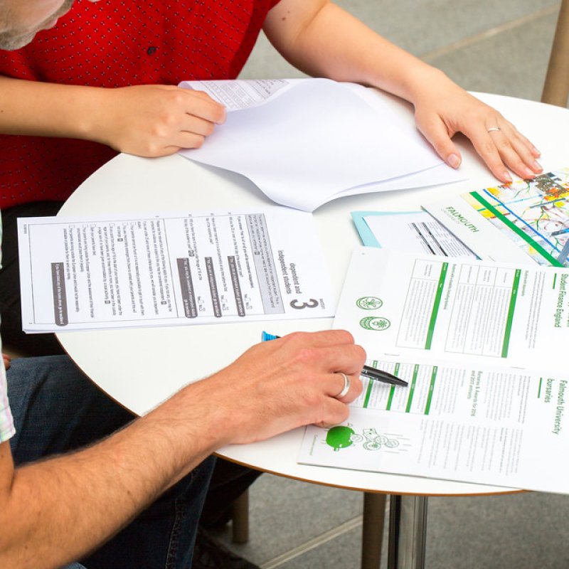 Two people sat at a desk doing paperwork