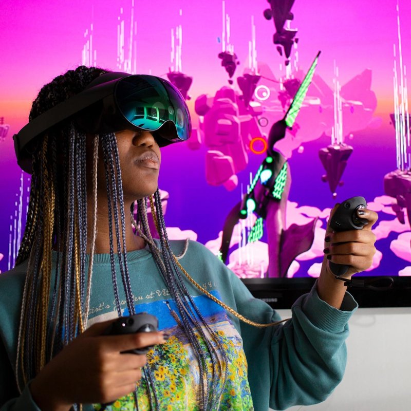 Falmouth University student wearing a VR headset in front of a pink screen