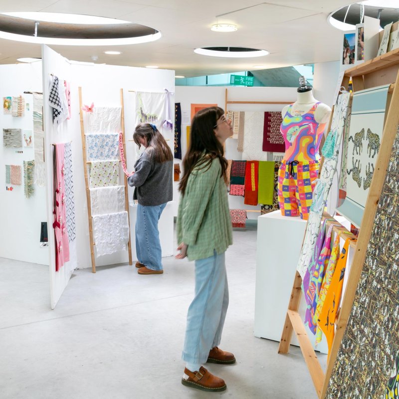 Two women looking at Textile Design student work at Falmouth University