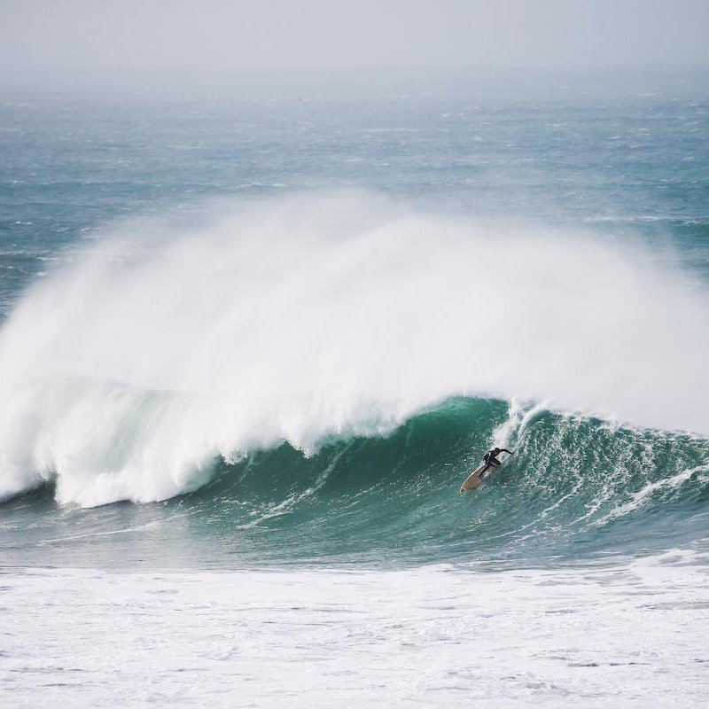 A surfer riding a large breaking wave