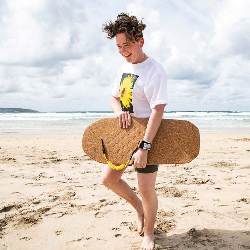 Model carrying cork bodyboard on beach